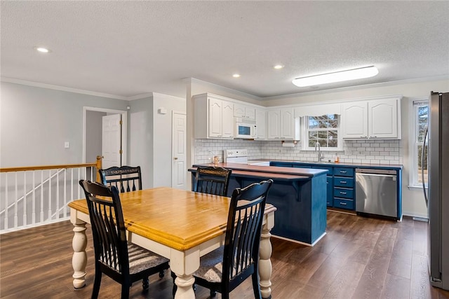 dining space featuring ornamental molding, plenty of natural light, dark wood finished floors, and a textured ceiling