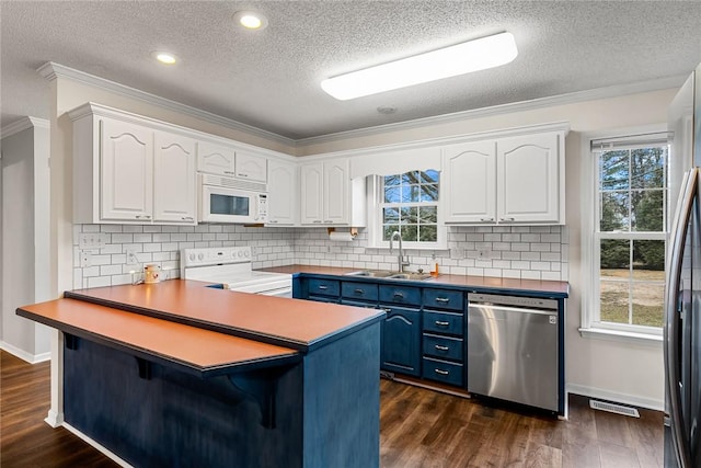 kitchen featuring blue cabinets, stainless steel appliances, a sink, white cabinetry, and dark wood finished floors