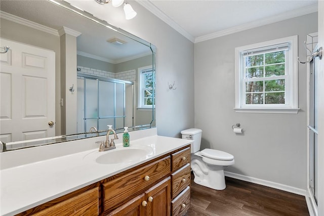 bathroom with wood finished floors, vanity, baseboards, ornamental molding, and a stall shower