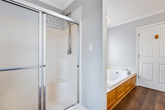 bathroom with wood finished floors, a stall shower, a garden tub, and crown molding