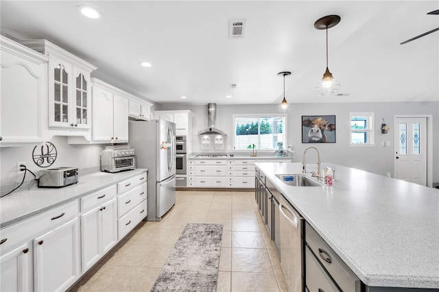 kitchen featuring white cabinets, wall chimney exhaust hood, sink, and stainless steel appliances