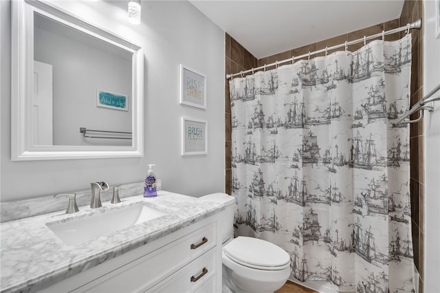 bathroom with walk in shower, vanity, and toilet