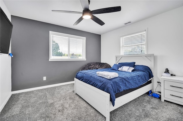 bedroom featuring ceiling fan, multiple windows, and carpet floors