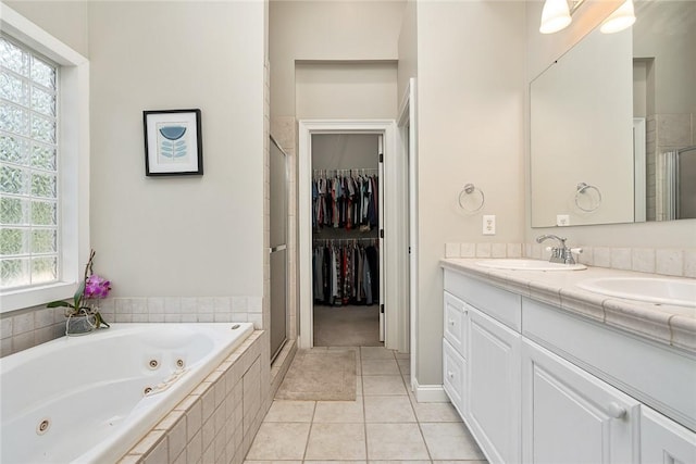 bathroom featuring plus walk in shower, tile patterned floors, and vanity