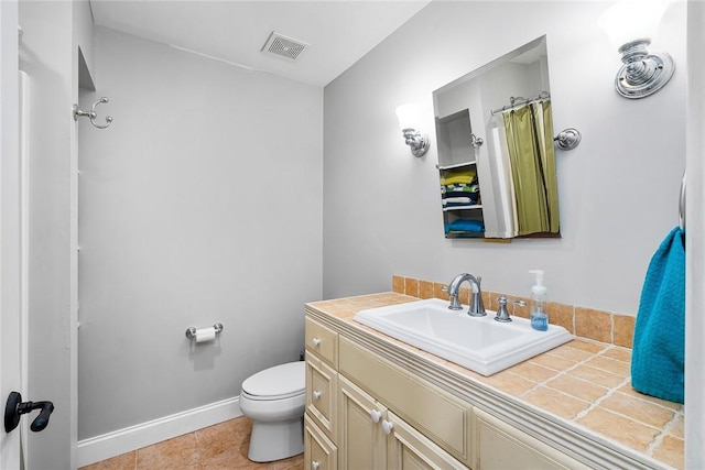 bathroom featuring toilet, vanity, and tile patterned flooring