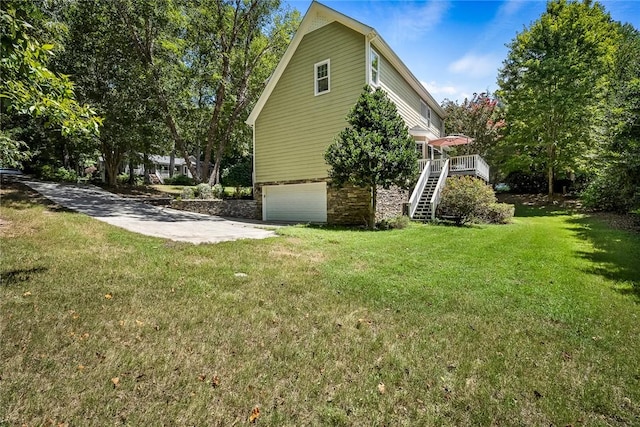 view of side of home with a garage, a deck, and a yard