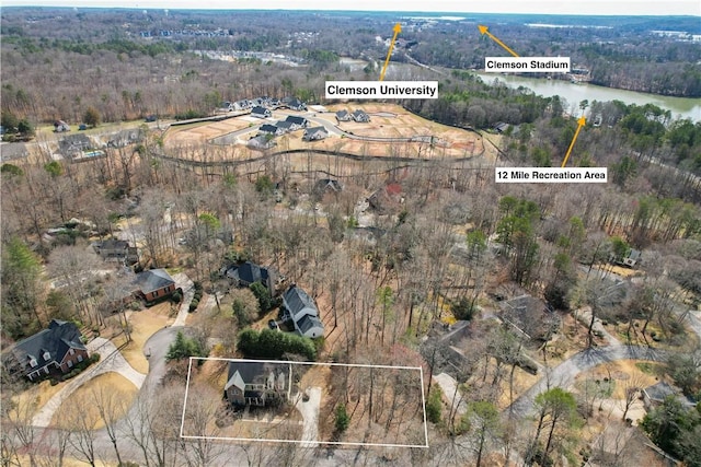 birds eye view of property with a view of trees and a water view