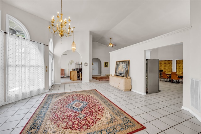 tiled foyer entrance featuring ceiling fan with notable chandelier and high vaulted ceiling