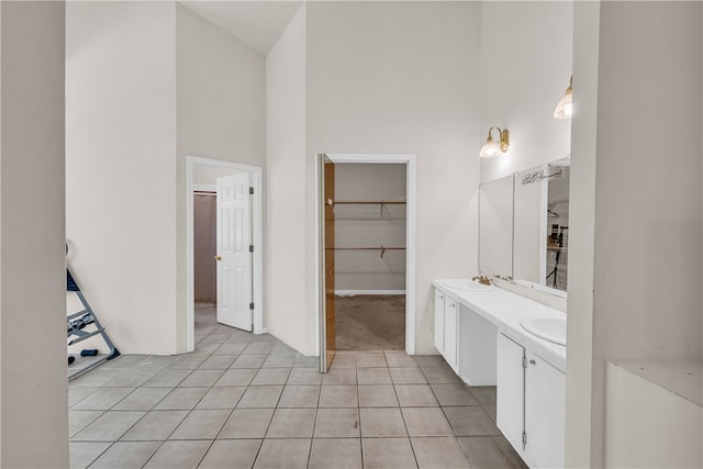 bathroom featuring tile patterned flooring, vanity, and high vaulted ceiling