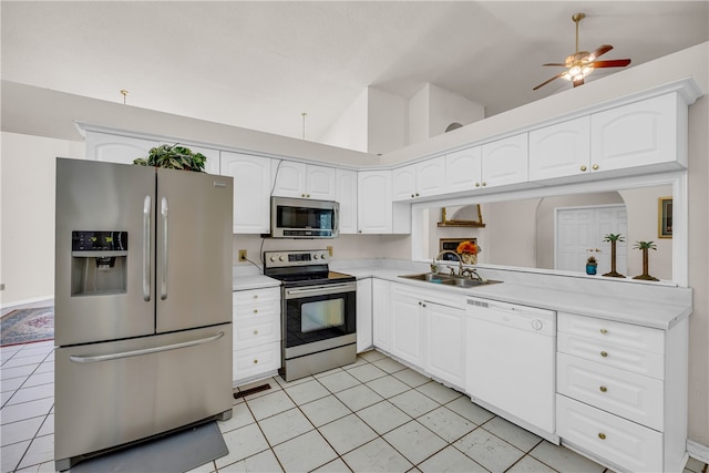 kitchen featuring appliances with stainless steel finishes, light tile patterned flooring, high vaulted ceiling, white cabinets, and sink