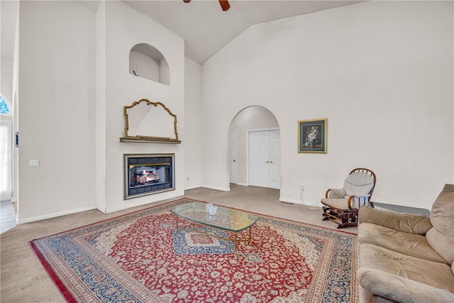 living room with ceiling fan, carpet flooring, and high vaulted ceiling