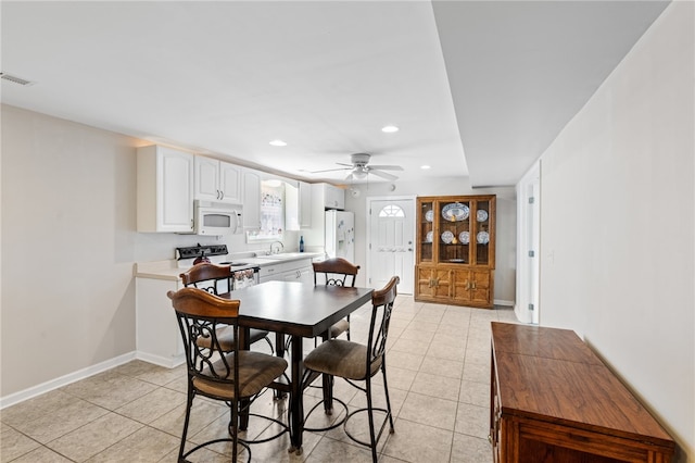 dining area with ceiling fan, light tile patterned flooring, and sink