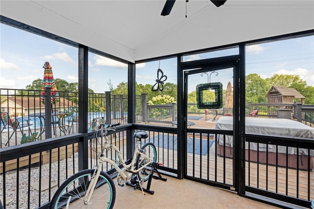 sunroom / solarium featuring vaulted ceiling, ceiling fan, and plenty of natural light