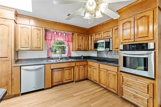 kitchen featuring appliances with stainless steel finishes, ceiling fan, light hardwood / wood-style flooring, and sink