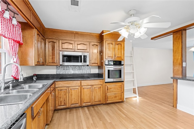 kitchen with ceiling fan, stainless steel appliances, sink, and light hardwood / wood-style flooring