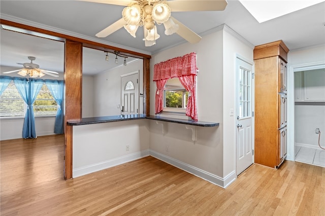 kitchen with ceiling fan, crown molding, light hardwood / wood-style floors, and kitchen peninsula