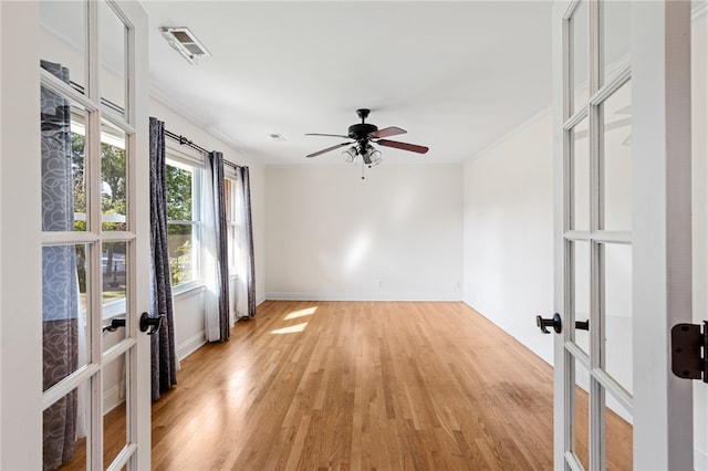 spare room with ornamental molding, ceiling fan, light hardwood / wood-style floors, and french doors