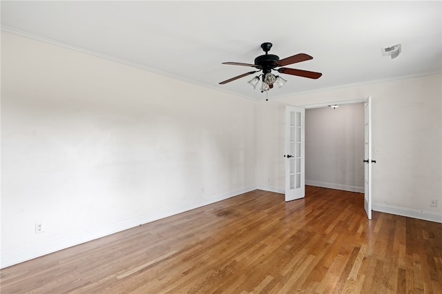 empty room with light wood-type flooring, crown molding, ceiling fan, and french doors