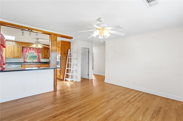 unfurnished living room featuring light hardwood / wood-style floors, ornamental molding, sink, and ceiling fan