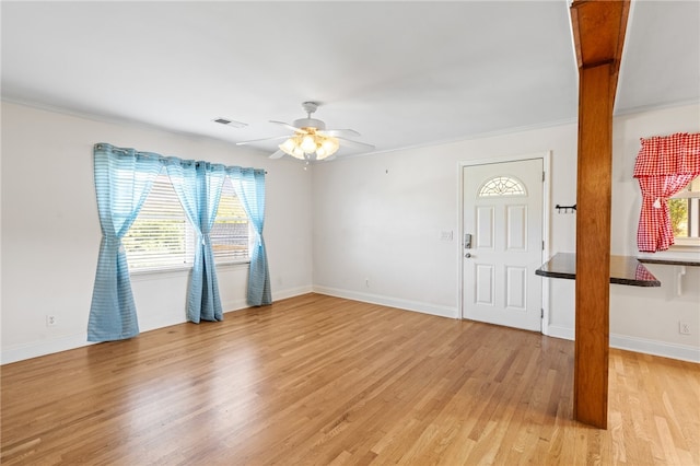 foyer entrance with ceiling fan, crown molding, and light hardwood / wood-style floors