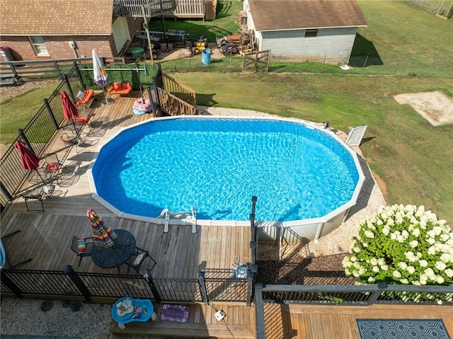 view of pool with a deck and a yard