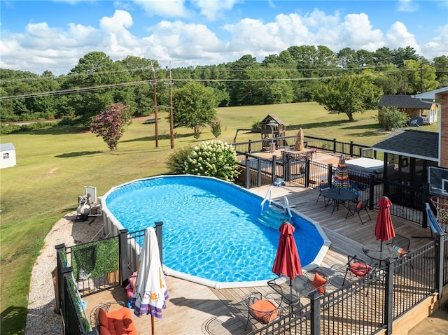 view of pool with a deck and a yard