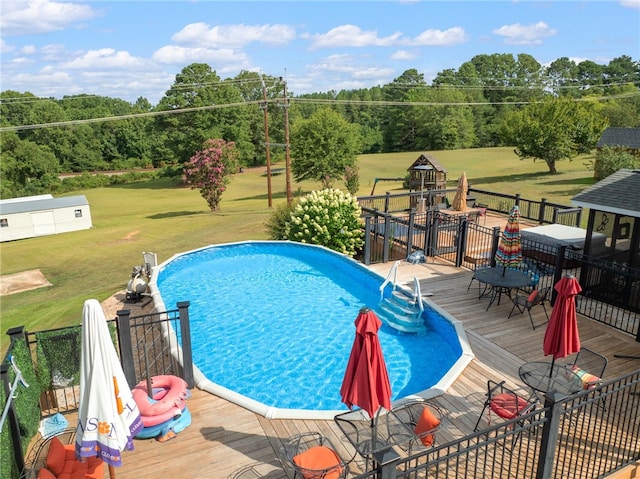 view of pool featuring a wooden deck and a yard