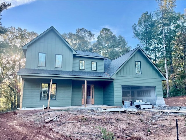 view of front of property featuring a garage, a porch, board and batten siding, and roof with shingles