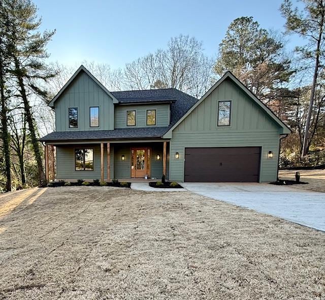 view of front of house featuring a porch, an attached garage, a shingled roof, driveway, and board and batten siding