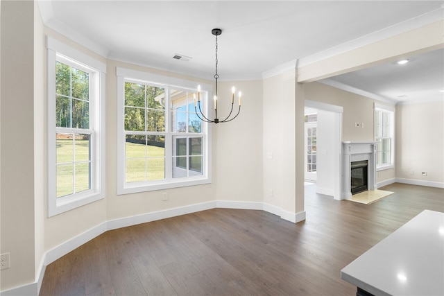 unfurnished dining area with a high end fireplace, hardwood / wood-style floors, ornamental molding, and a chandelier