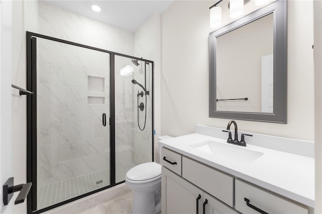 bathroom featuring vanity, a shower with shower door, and toilet