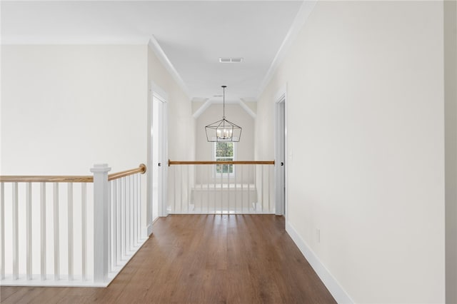 hall featuring ornamental molding, an inviting chandelier, and hardwood / wood-style floors