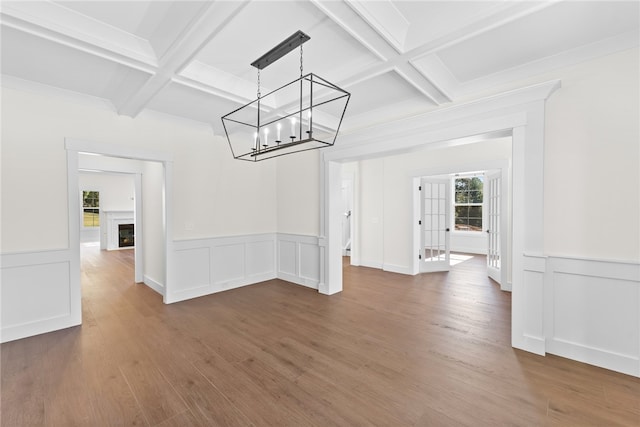 unfurnished dining area with beamed ceiling, coffered ceiling, and dark wood-type flooring