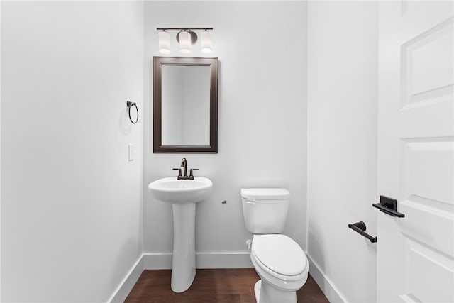 bathroom featuring hardwood / wood-style flooring and toilet