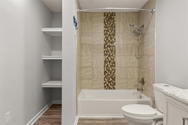 full bathroom with wood-type flooring, tiled shower / bath combo, toilet, and vanity