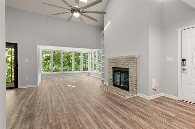 unfurnished living room featuring a ceiling fan, high vaulted ceiling, and wood finished floors