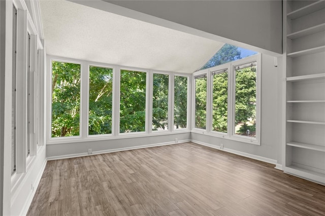 unfurnished sunroom featuring a healthy amount of sunlight and lofted ceiling