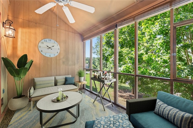 sunroom with a ceiling fan, wooden walls, and outdoor lounge area