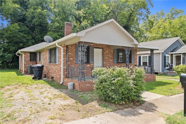 view of front facade with a front lawn, central AC, and covered porch