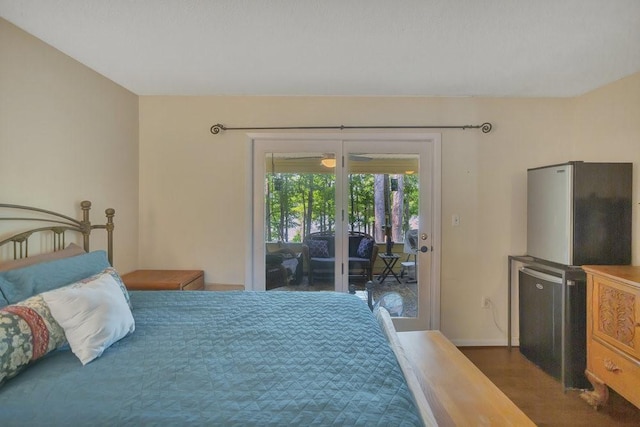 bedroom with access to exterior, dark wood-type flooring, and stainless steel fridge