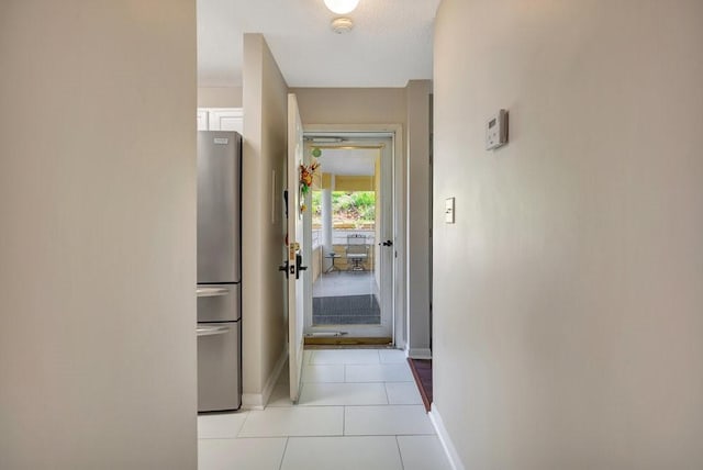 corridor featuring a textured ceiling and light tile patterned floors