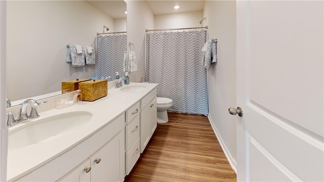 bathroom with curtained shower, wood-type flooring, vanity, and toilet