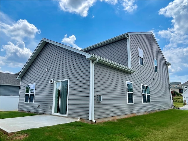 back of property with a lawn and a patio area