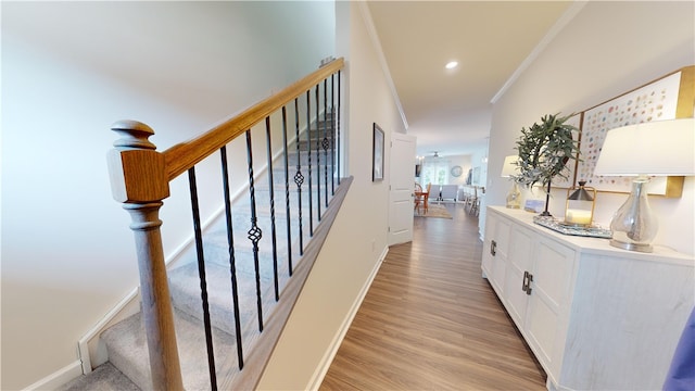 hall with ornamental molding and light hardwood / wood-style flooring