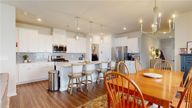 dining area featuring crown molding, dark hardwood / wood-style floors, a chandelier, and sink