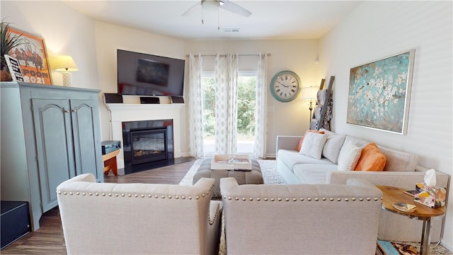 living room featuring ceiling fan and dark wood-type flooring