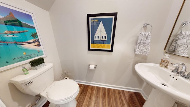 bathroom with hardwood / wood-style flooring, sink, and toilet