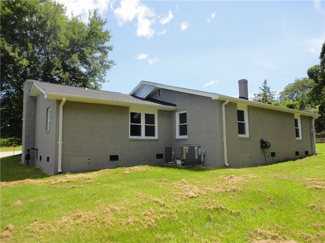 back of house featuring central AC and a yard