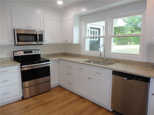 kitchen featuring light hardwood / wood-style floors, stainless steel appliances, sink, and white cabinetry