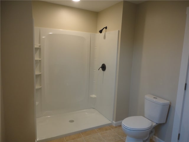 bathroom featuring walk in shower, tile patterned floors, and toilet